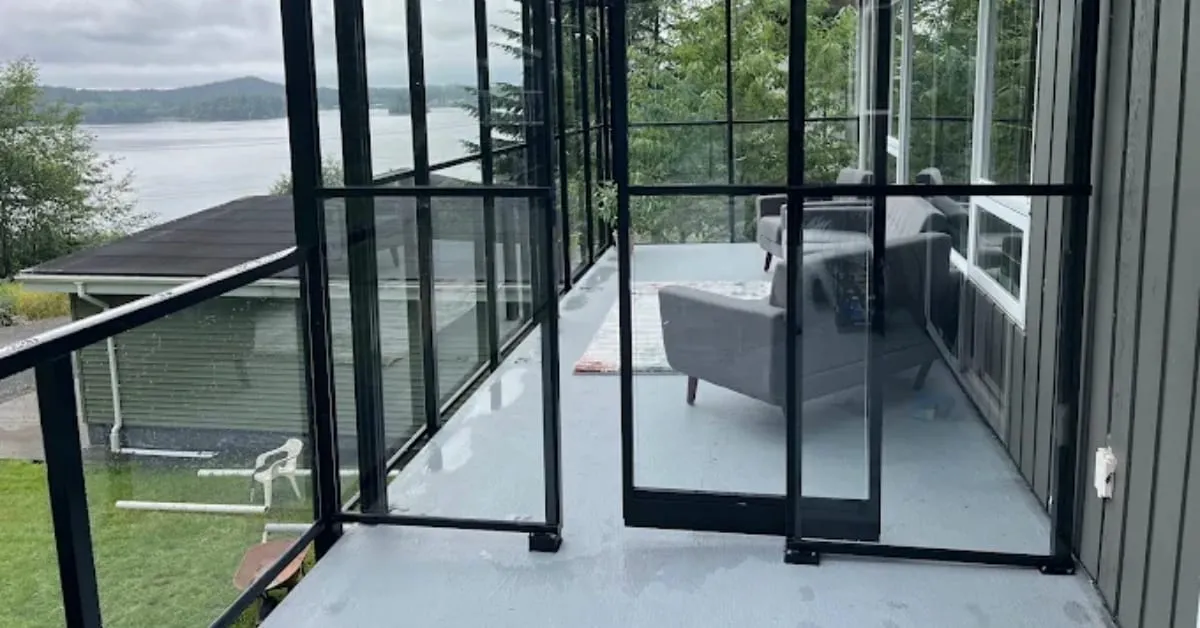 Black-framed glass railing on a covered deck with a lake view